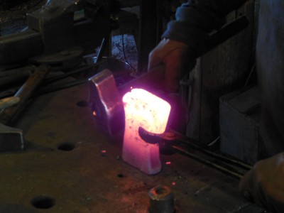 The axe body with inserted bit is "packed" together at a high heat before welding begins.  Norwegian smiths like to heat the weld-zone to a high heat to tighten the gaps between the pieces and even up the edges before they actually start forge welding.